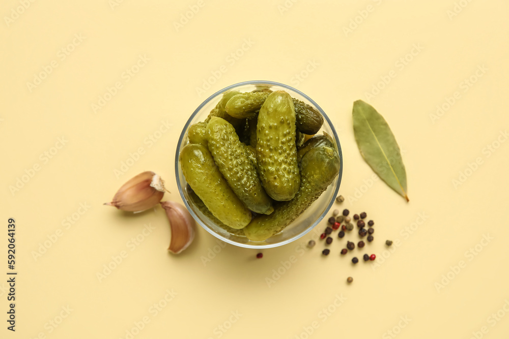 Bowl with tasty fermented cucumbers and ingredients on beige background