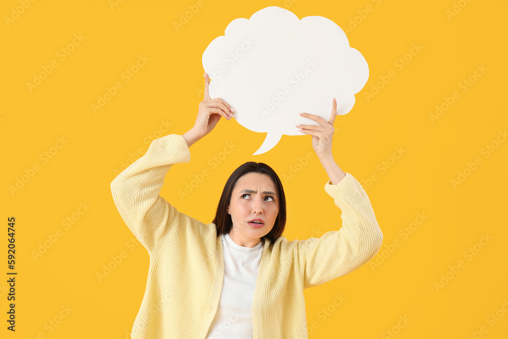 Upset young woman with blank speech bubble on yellow background