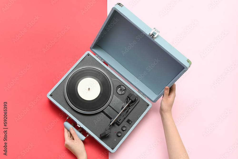 Woman with record player on color background