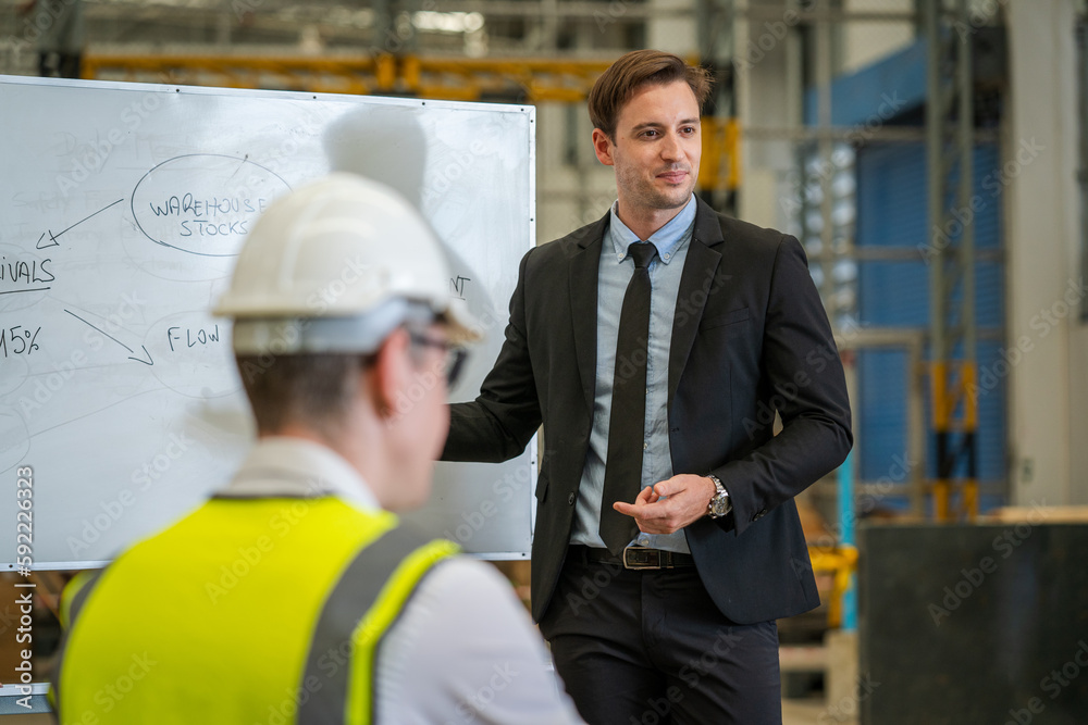 Warehouse manager meeting with his team in a large distribution warehouse.