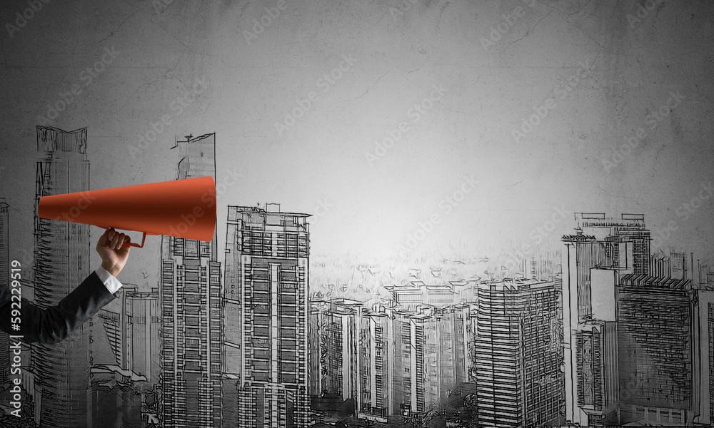 Hand of businesswoman holding red paper trumpet against cityscape background