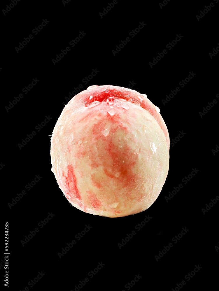 Closeup of a peach with droplets on a black background