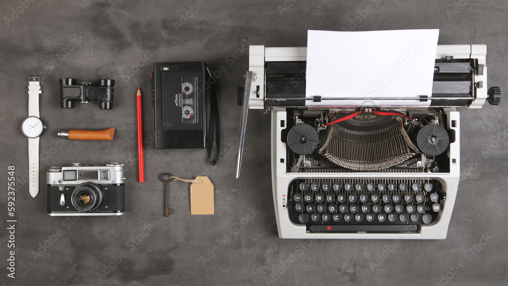 vintage typewriter and tape recorder on the table with blank paper on the desk - concept for writing