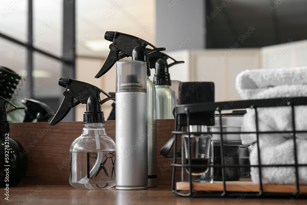 Different hair sprays on table in beauty salon