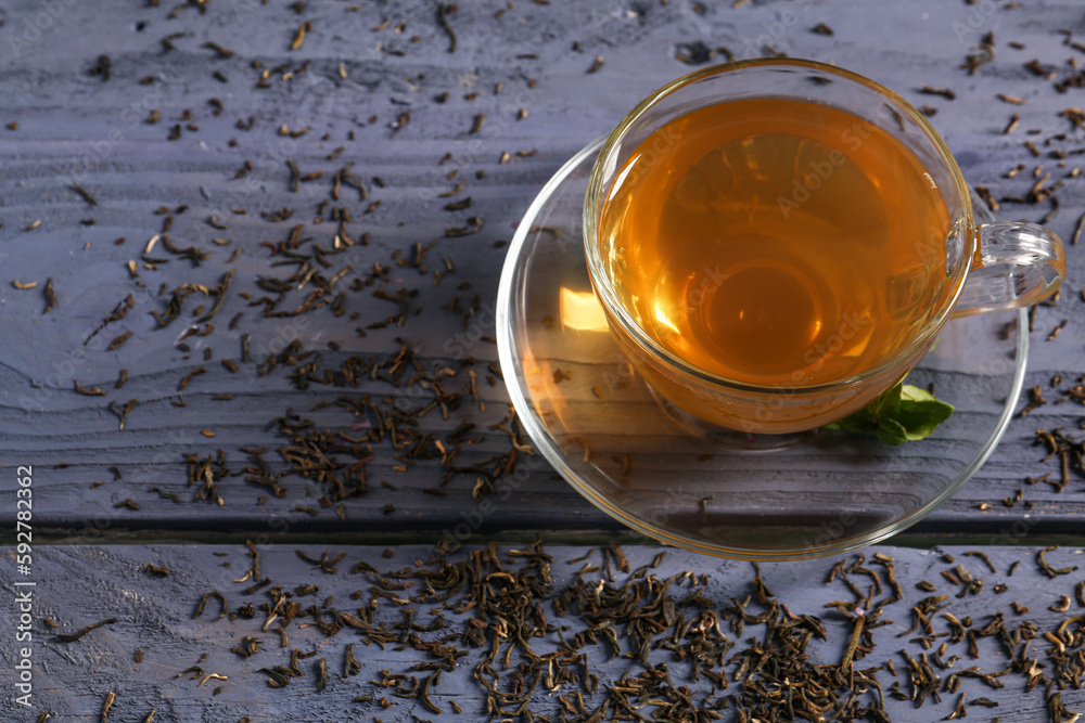 Cup of hot green tea on blue wooden background