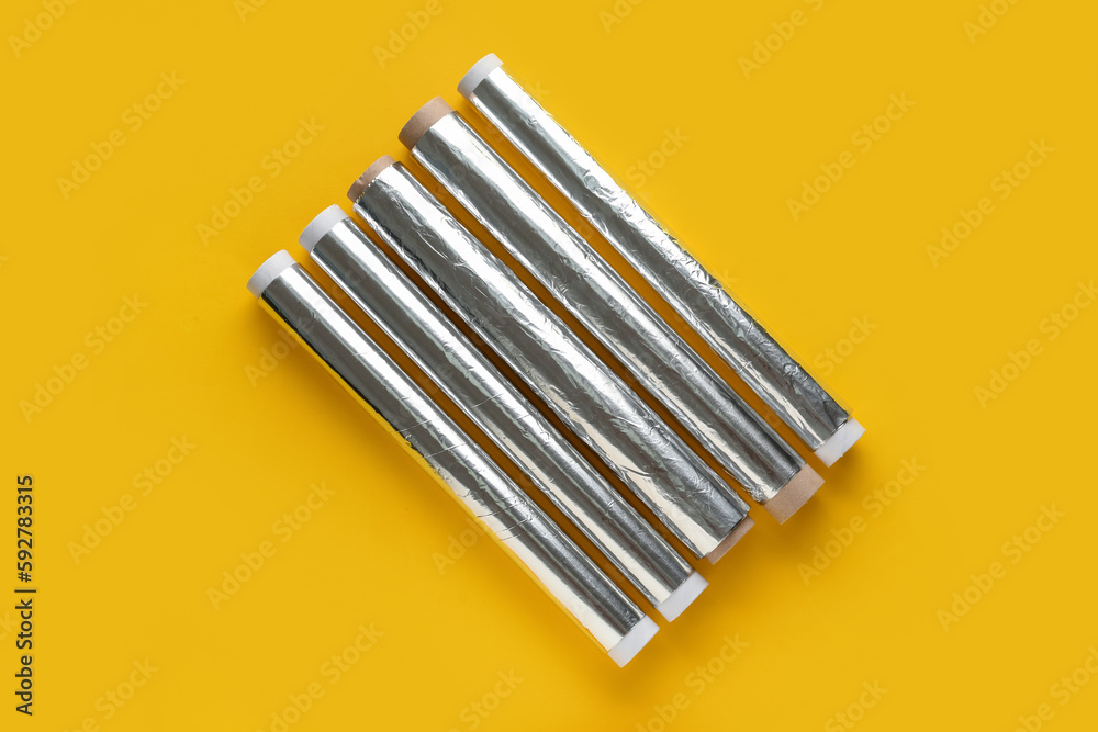 Aluminium foil rolls on yellow background