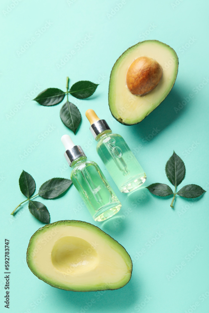 Composition with bottles of cuticle oil, avocado and plant leaves on color background