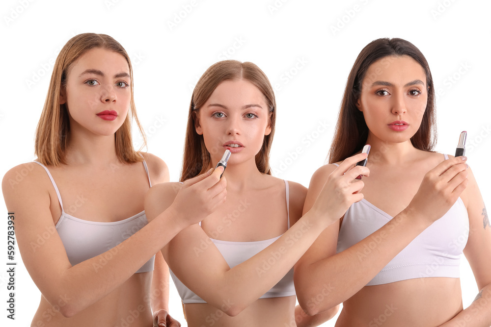 Young women with lipsticks on white background