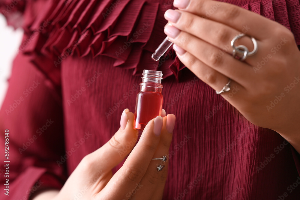 Woman holding bottle of cuticle oil, closeup