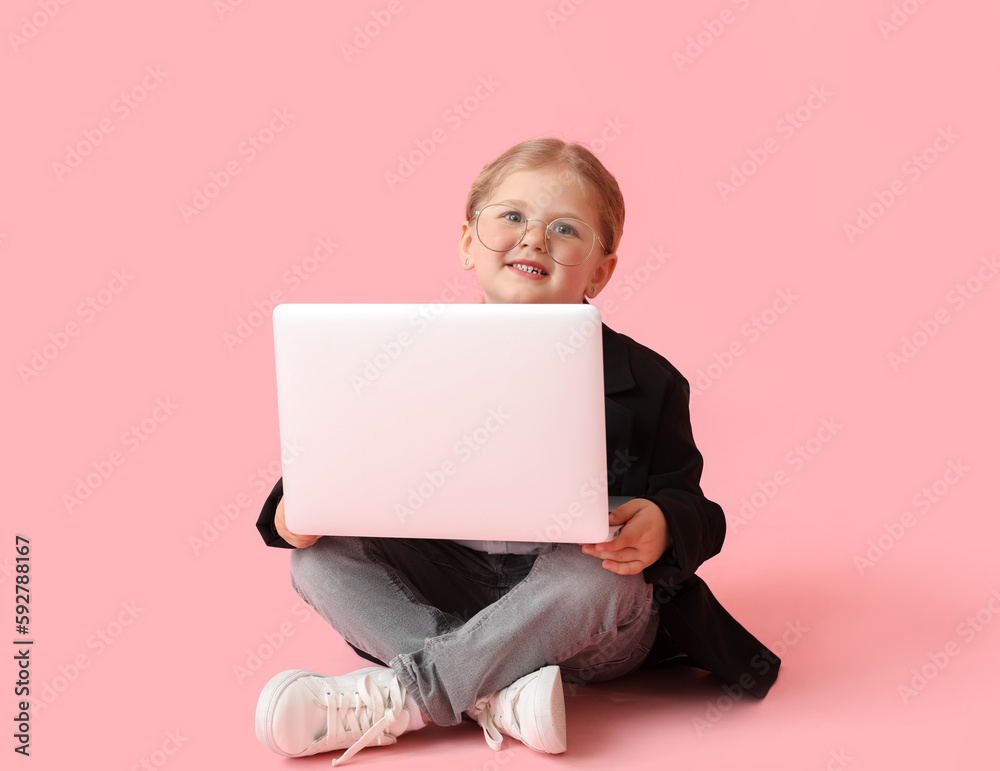 Funny little businesswoman with laptop sitting on pink background