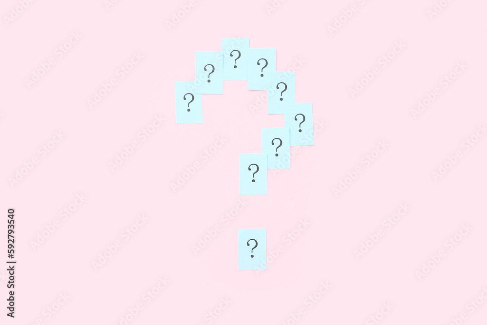 Question mark made of papers on pink background