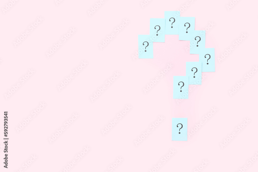 Question mark made of papers on pink background