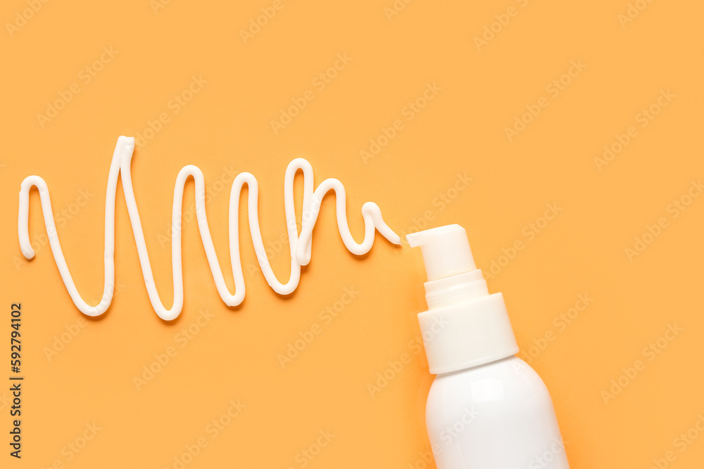 Sunscreen cream on orange background