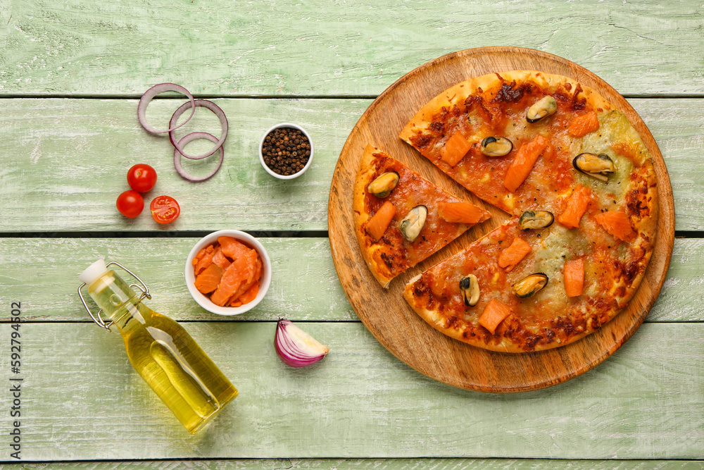 Plate of tasty seafood pizza and ingredients on light wooden background