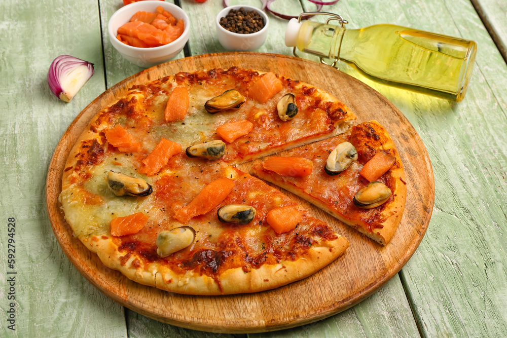 Plate of tasty seafood pizza on light wooden background