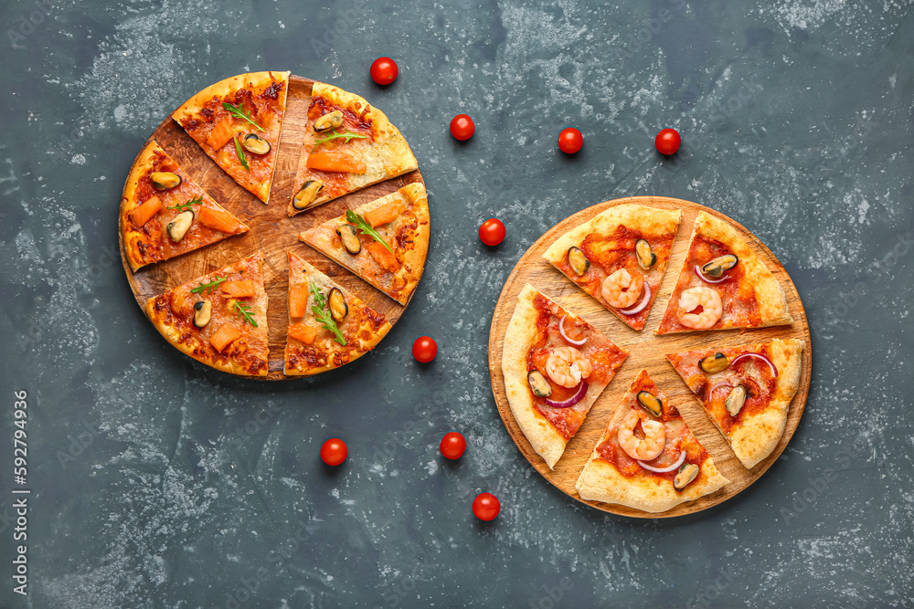 Plates of tasty seafood pizza on blue background