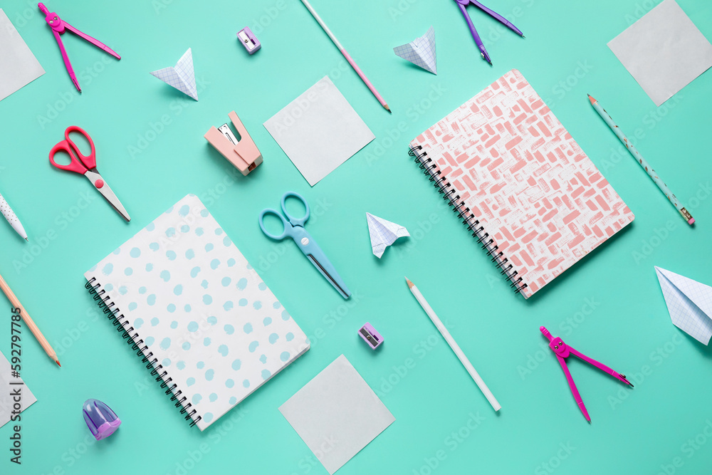 Composition with stationery supplies and paper plane on turquoise background