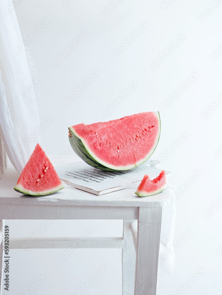 Vertical shot of slices of watermelon on a white wooden board on a white background