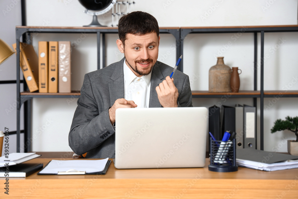 Male tutor with pen giving online lesson at home