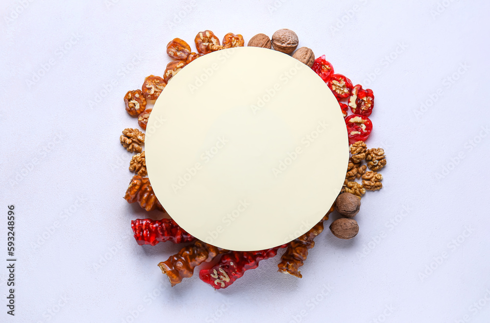 Blank card and frame made of delicious churchkhela with ingredients on white background