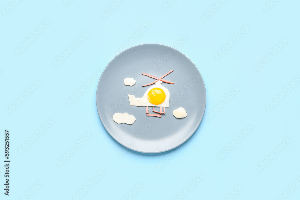 Plate with funny childrens breakfast in shape of helicopter on blue background