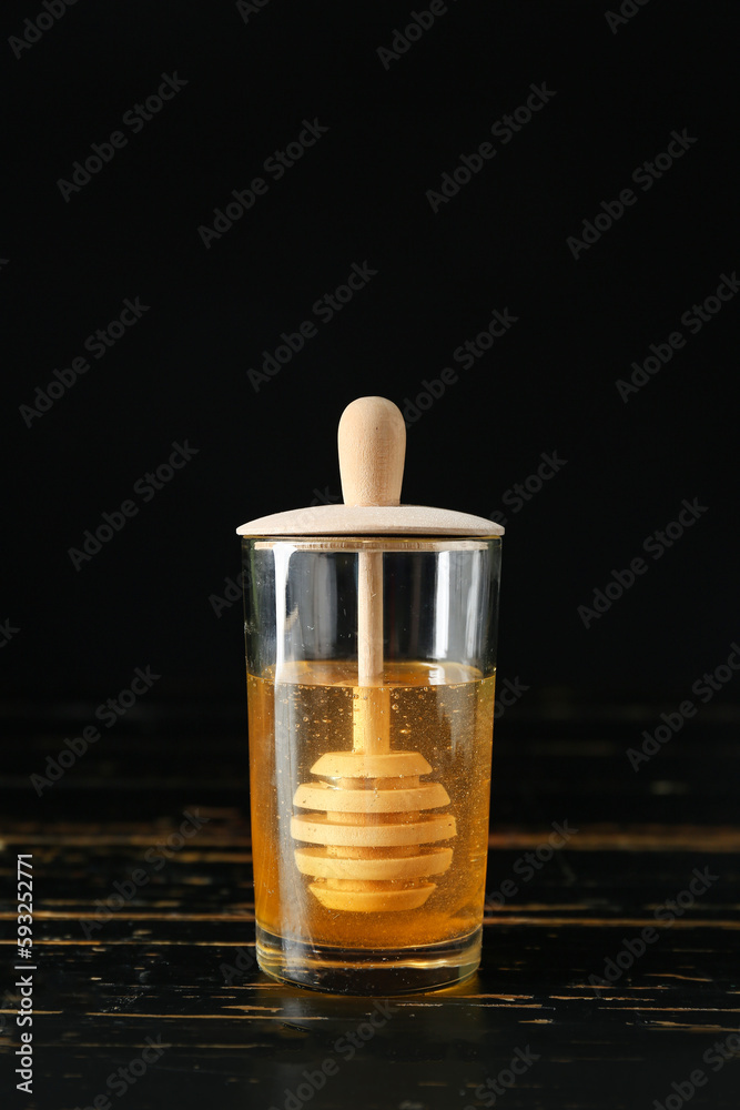 Jar of sweet honey with dipper on table