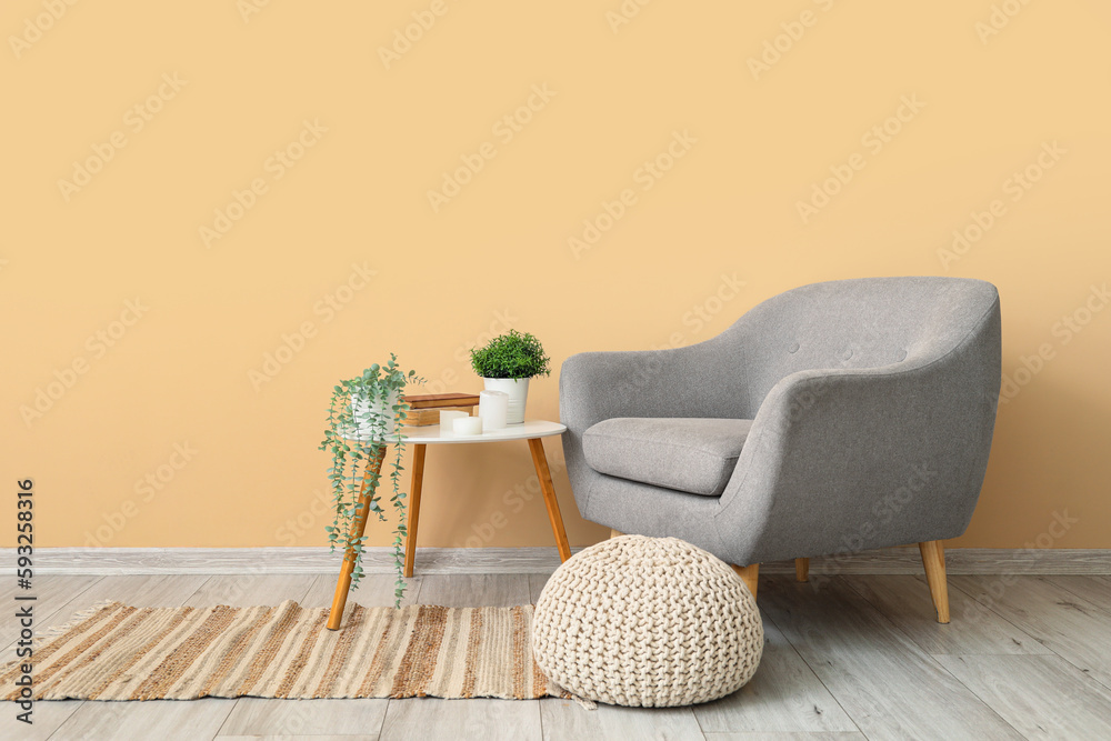 Interior of living room with armchair and artificial plants on table