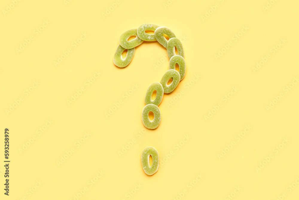 Question mark made of jelly candies on yellow background