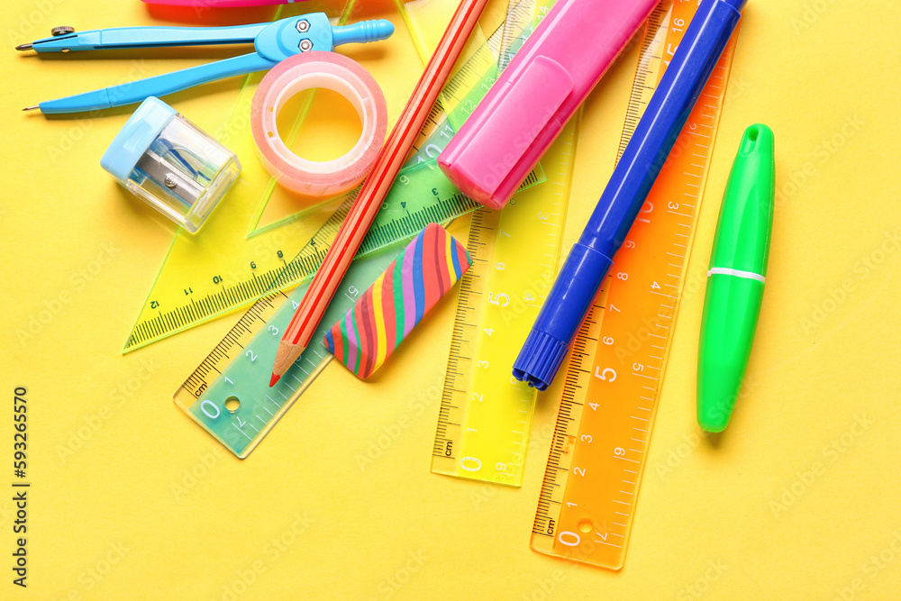 Colorful stationery supplies on yellow background