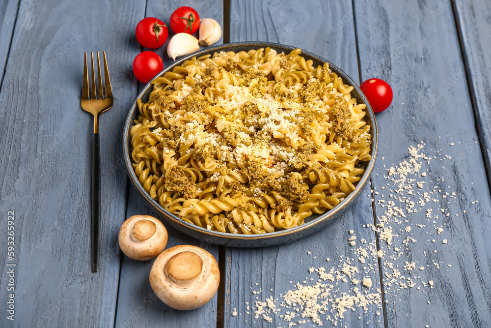 Plate of tasty Italian pasta with Parmesan cheese on wooden background