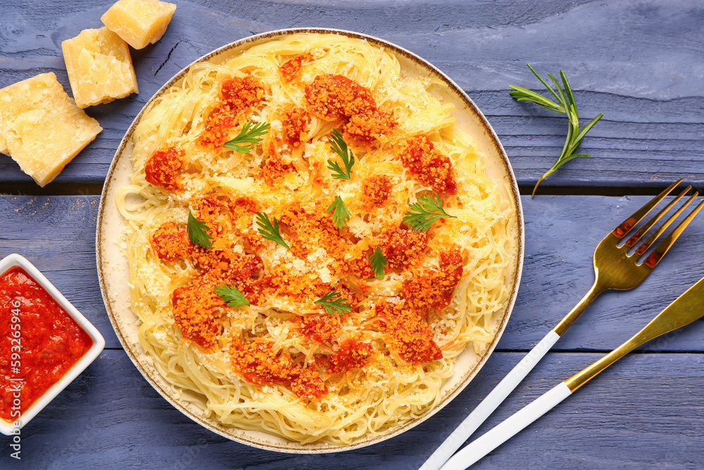 Plate of tasty Italian pasta with Parmesan cheese on wooden background