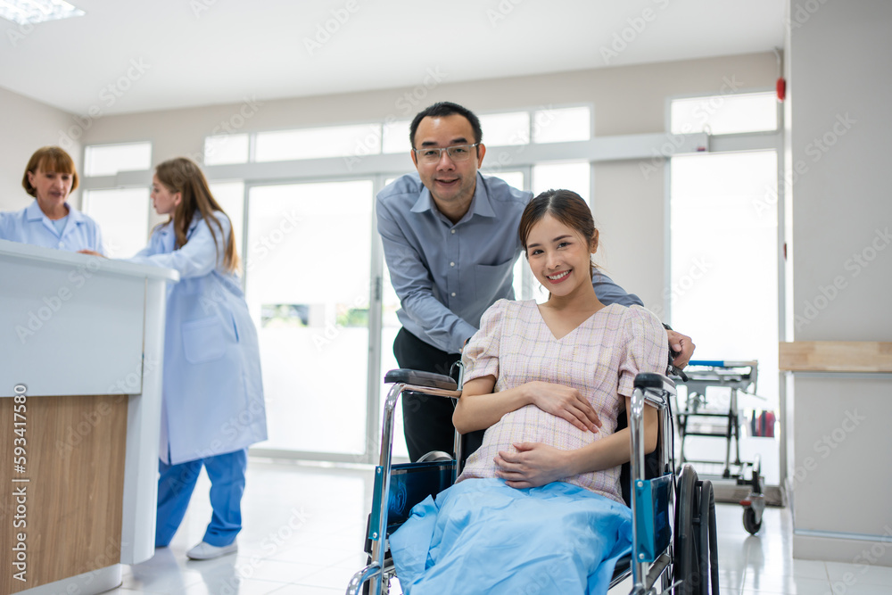 Portrait of Asian husband taking care of pregnant woman in wheelchair. 