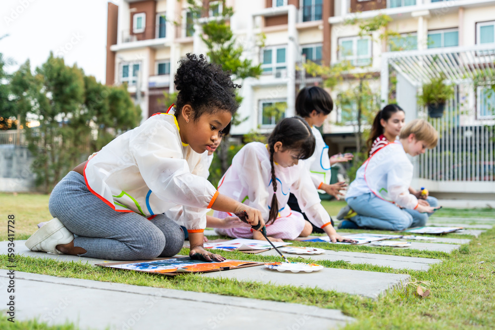 Group of student coloring on painting board outdoors in school garden. 