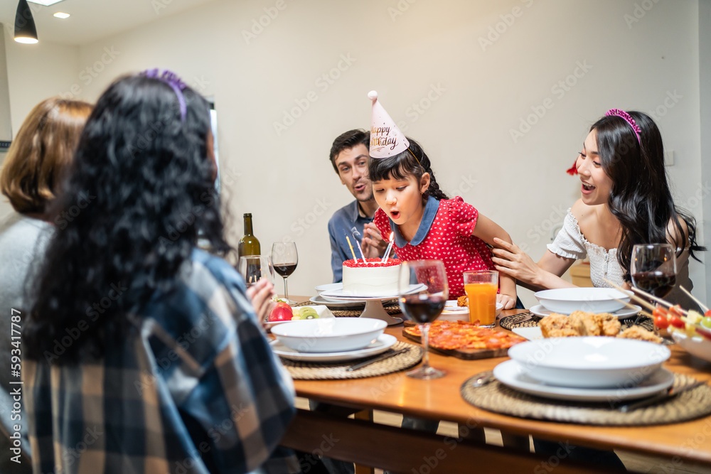 Multi-ethnic big family having a birthday party for young kid daughter. 