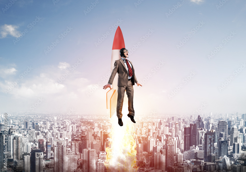 Business person in aviator hat flying on rocket