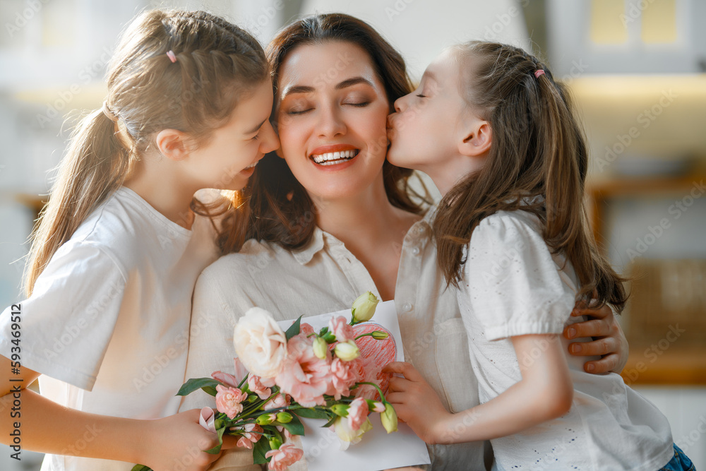 Daughters giving mother bouquet of flowers.