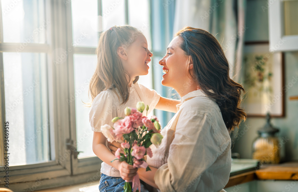 Daughter giving mother bouquet of flowers.