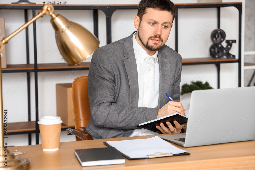 Male tutor with notebook giving online lesson at home