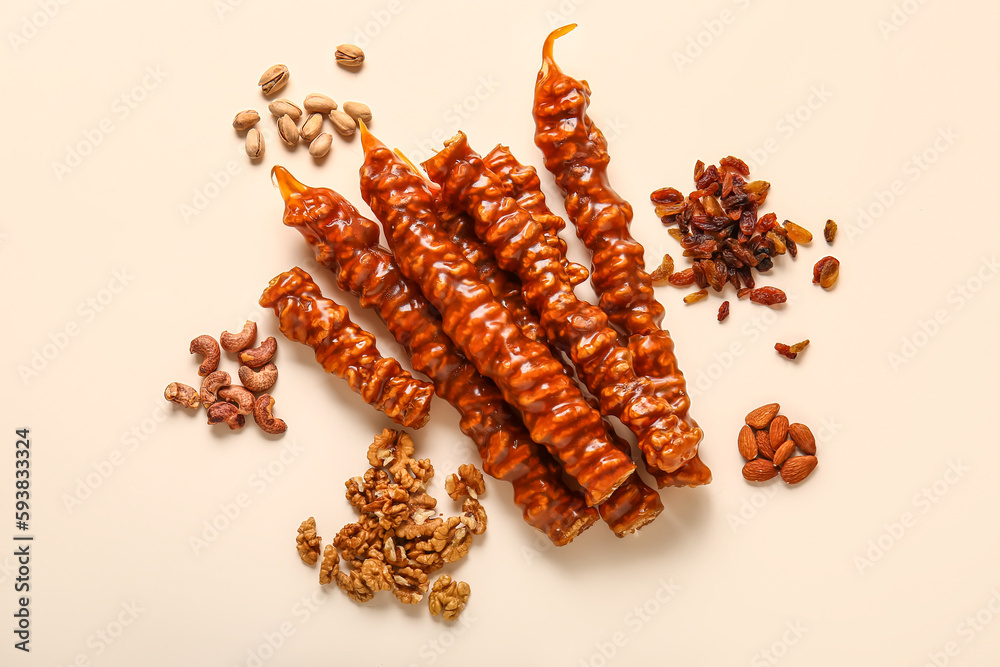 Pile of tasty churchkhela, nuts and raisin on light background