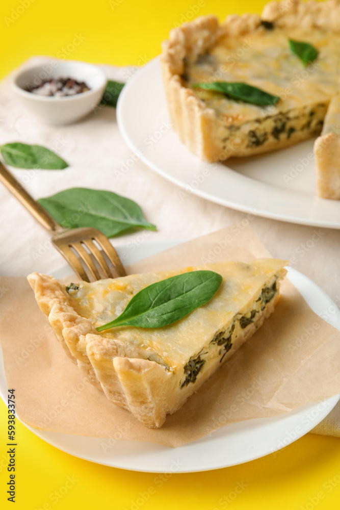 Plate with piece of delicious quiche on yellow background