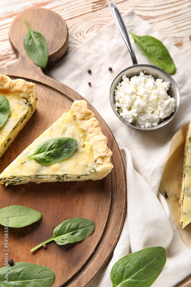 Board with piece of delicious quiche and cottage cheese on white wooden background