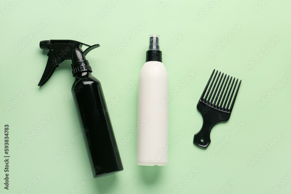 Bottles of hair sprays with comb on color background