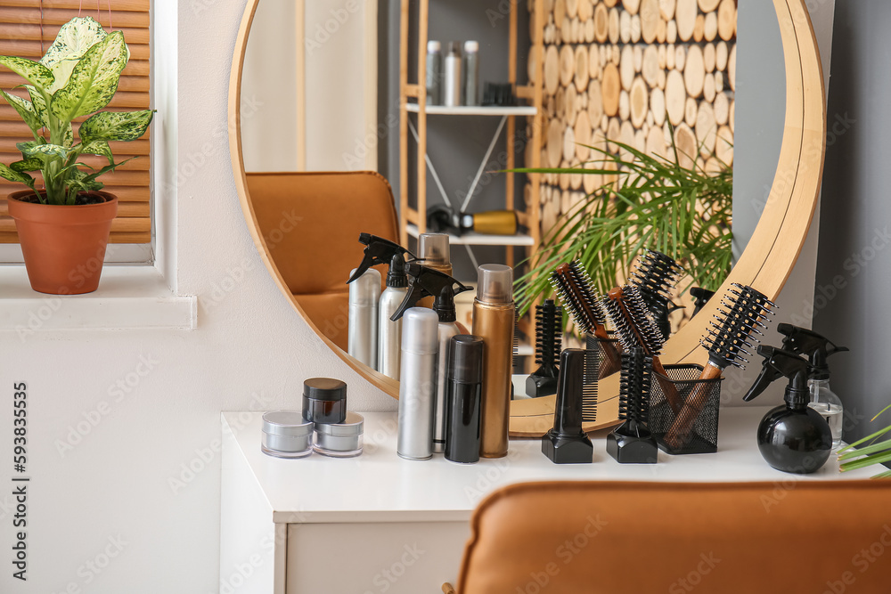 Hair sprays with accessories on table in beauty salon