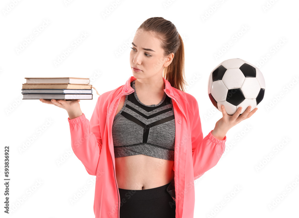 Sporty young woman with books and soccer ball on white background. Balance concept