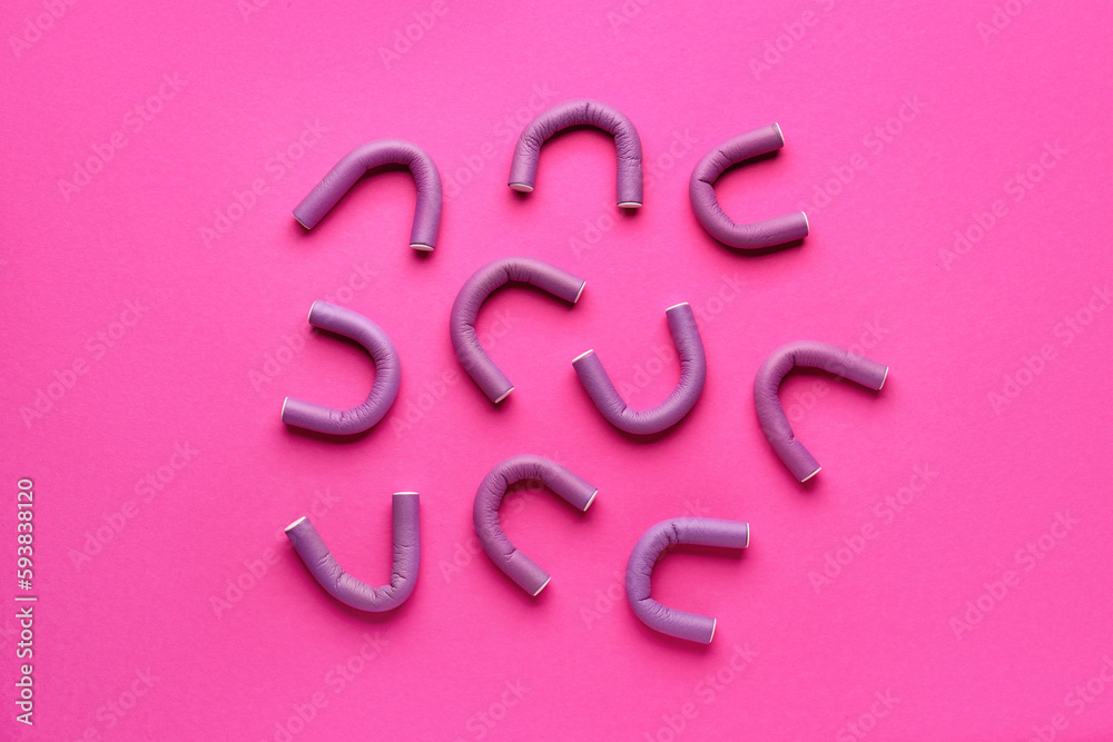 Hair curlers on pink background