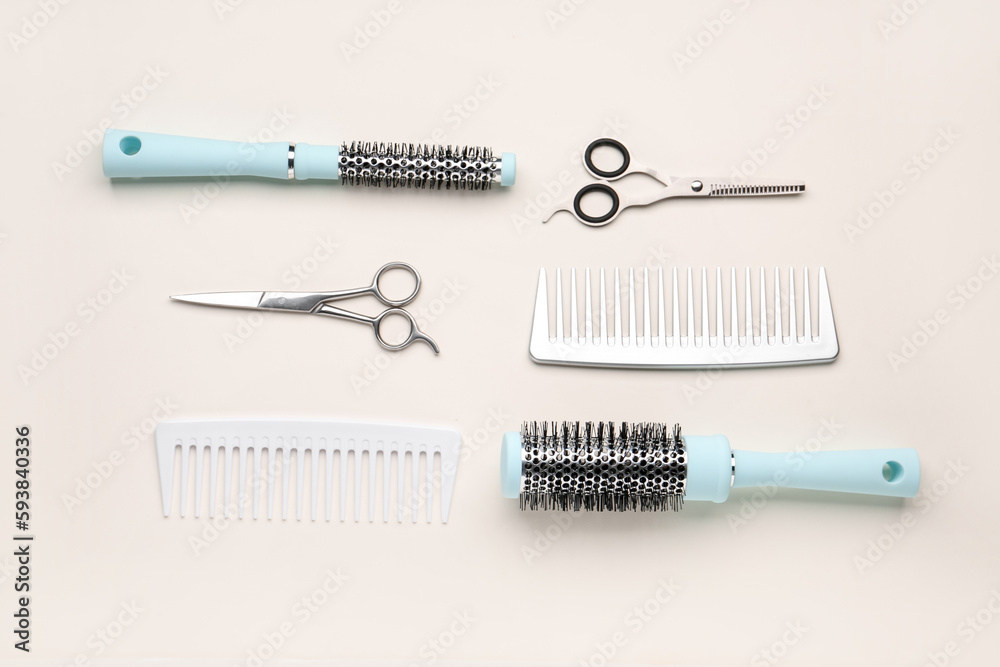 Hair brushes with scissors on beige background