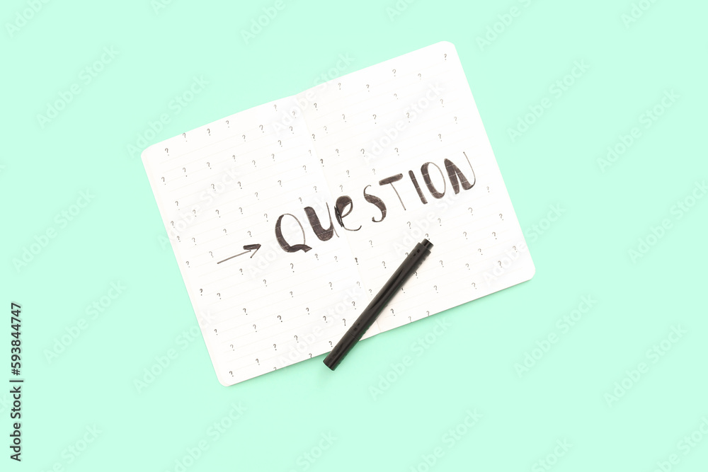 Notebook with word QUESTION and drawn marks on green background