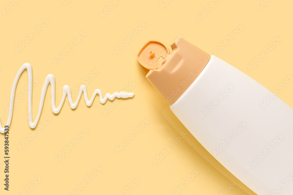 Bottle of sunscreen cream on beige background, closeup