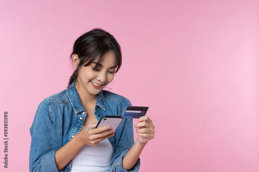 Young beauty Asian woman shopping payment online with credit card on smartphone and she wearing jean