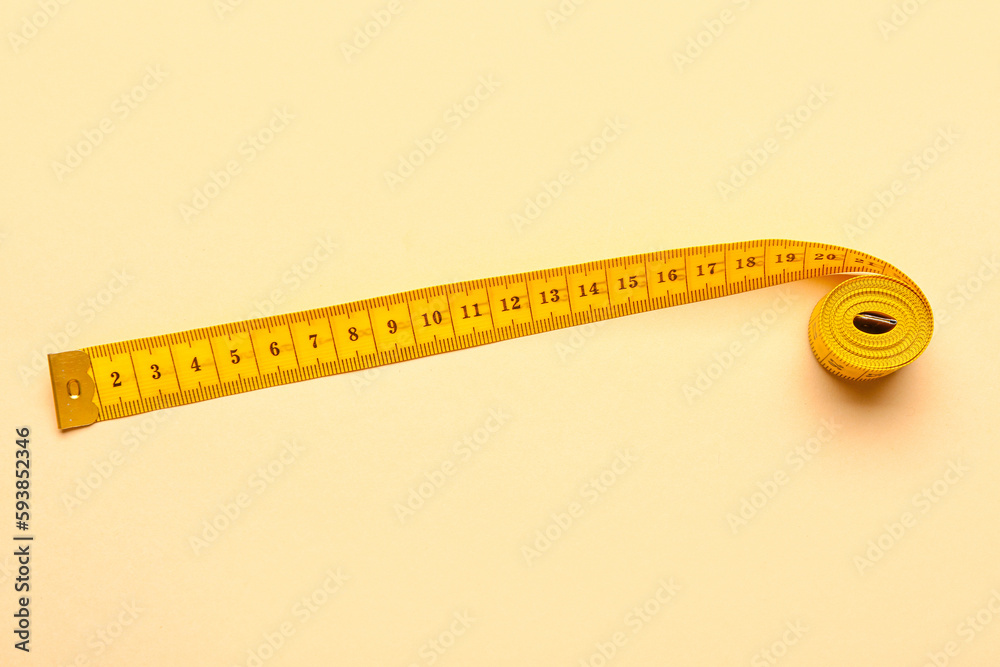 Orange measuring tape on beige background